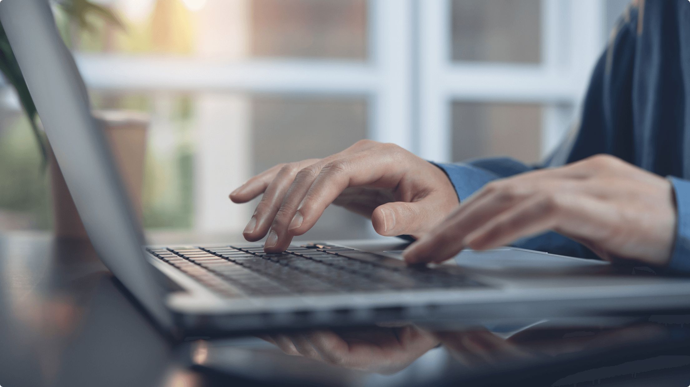 ノートパソコンでタイピングする男性