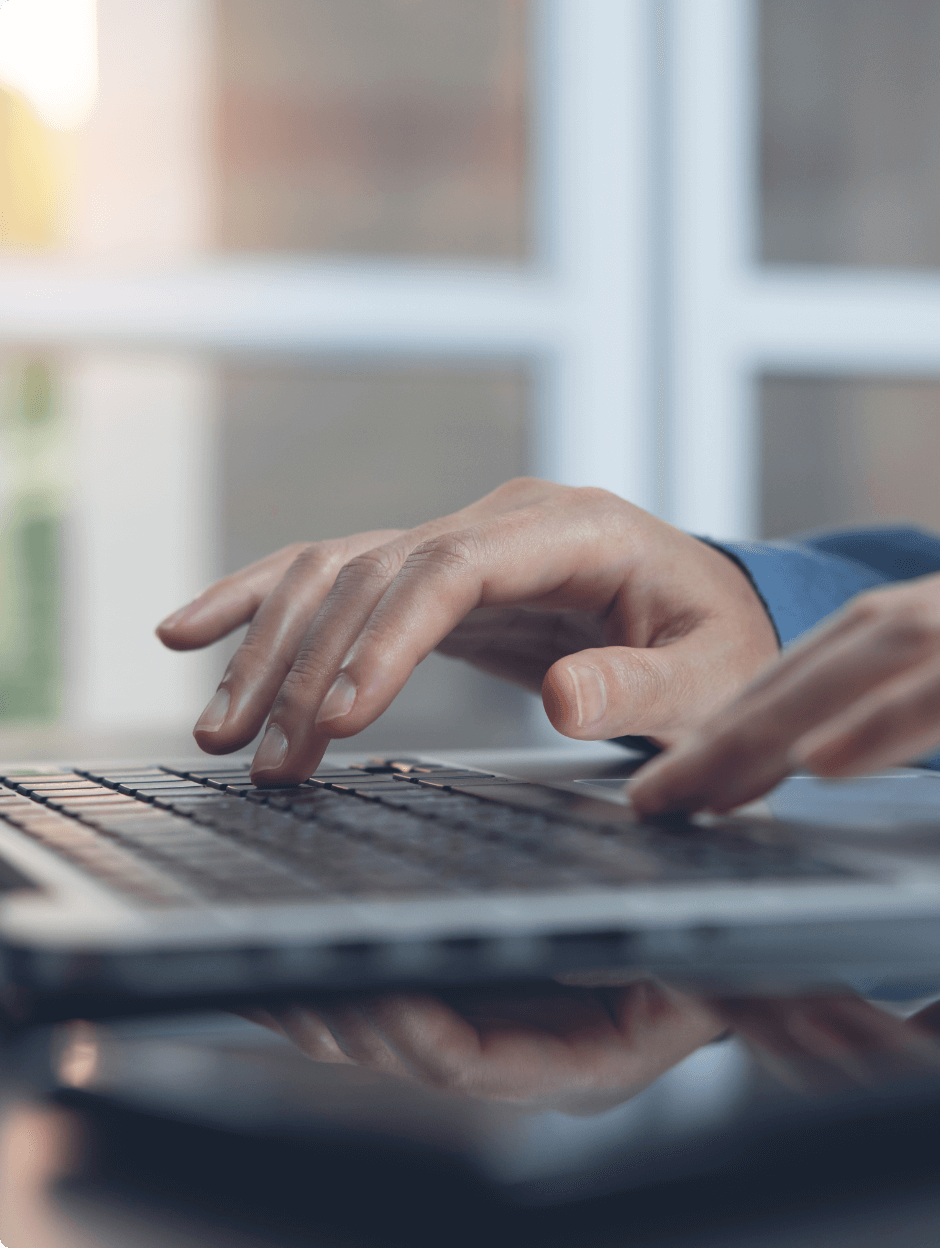 ノートパソコンでタイピングする男性